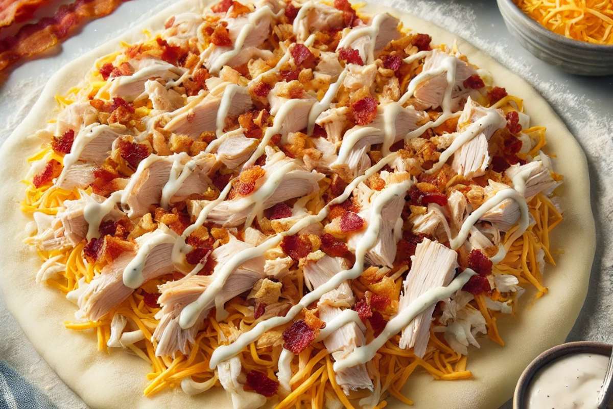 Assembling Chicken Bacon Ranch Stromboli with layered ingredients on pizza dough