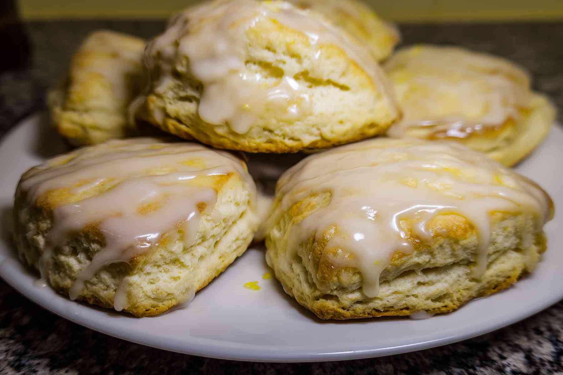 Homemade lemon scones on plate with crumbs and natural light