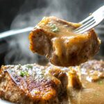 Pork chops in the crock pot covered in creamy onion gravy