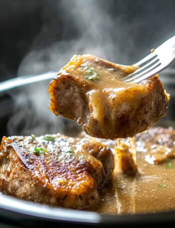 Pork chops in the crock pot covered in creamy onion gravy