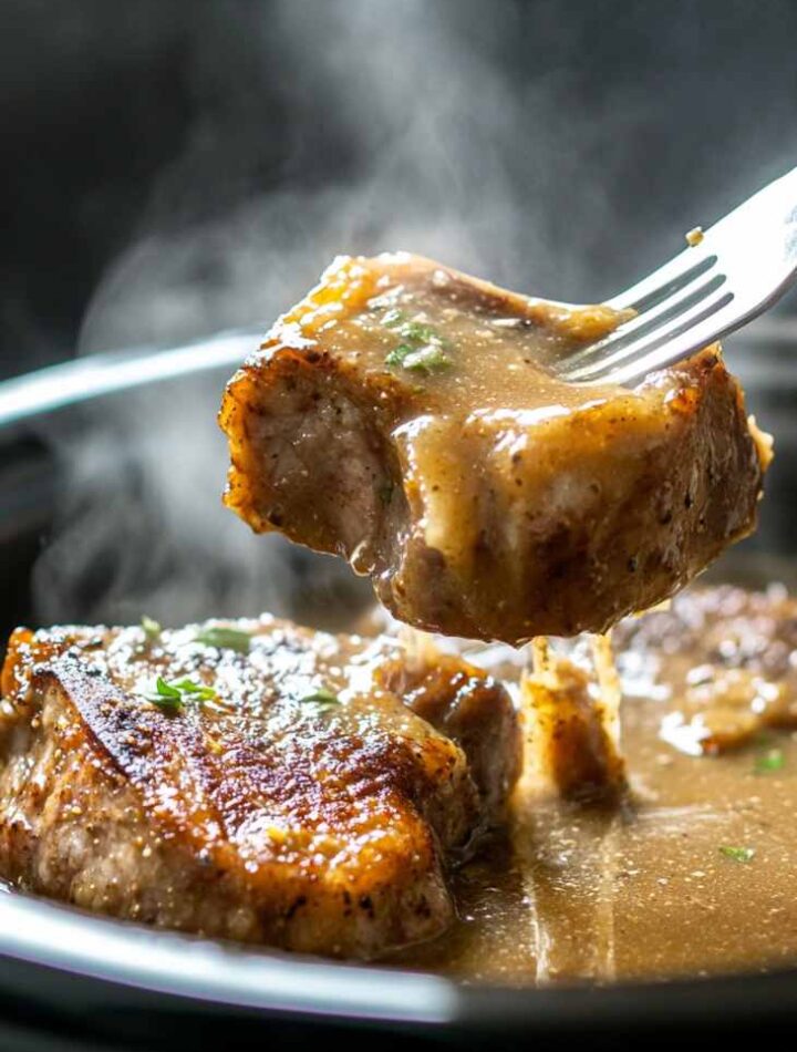 Pork chops in the crock pot covered in creamy onion gravy