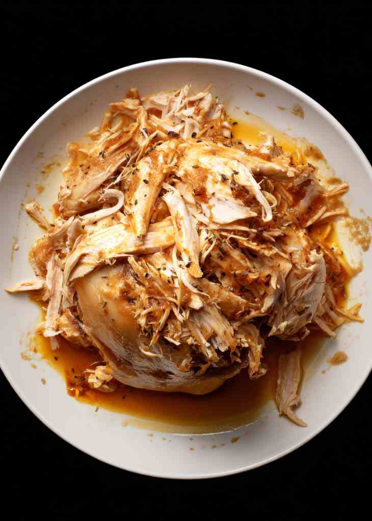 Raw chicken breasts in crockpot with onions and broth