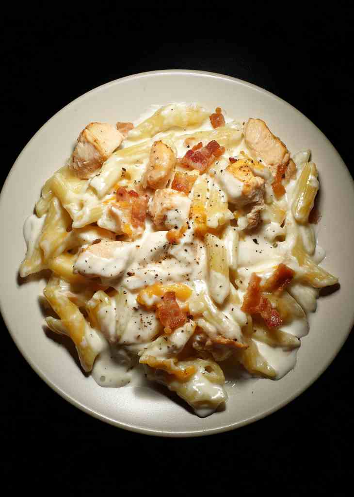 Plated chicken bacon ranch pasta with creamy sauce and bacon bits