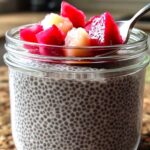 Chia seed pudding in a glass jar with spoon on wooden table