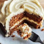 Homemade carrot cake with cream cheese frosting in round pan