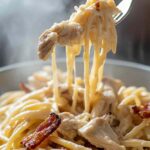 Chicken bacon ranch pasta in skillet with creamy sauce and bacon