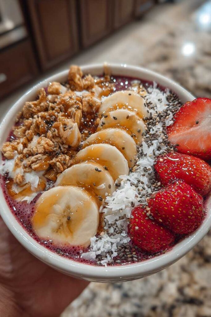Pouring thick berry smoothie into bowl for smoothie bowls