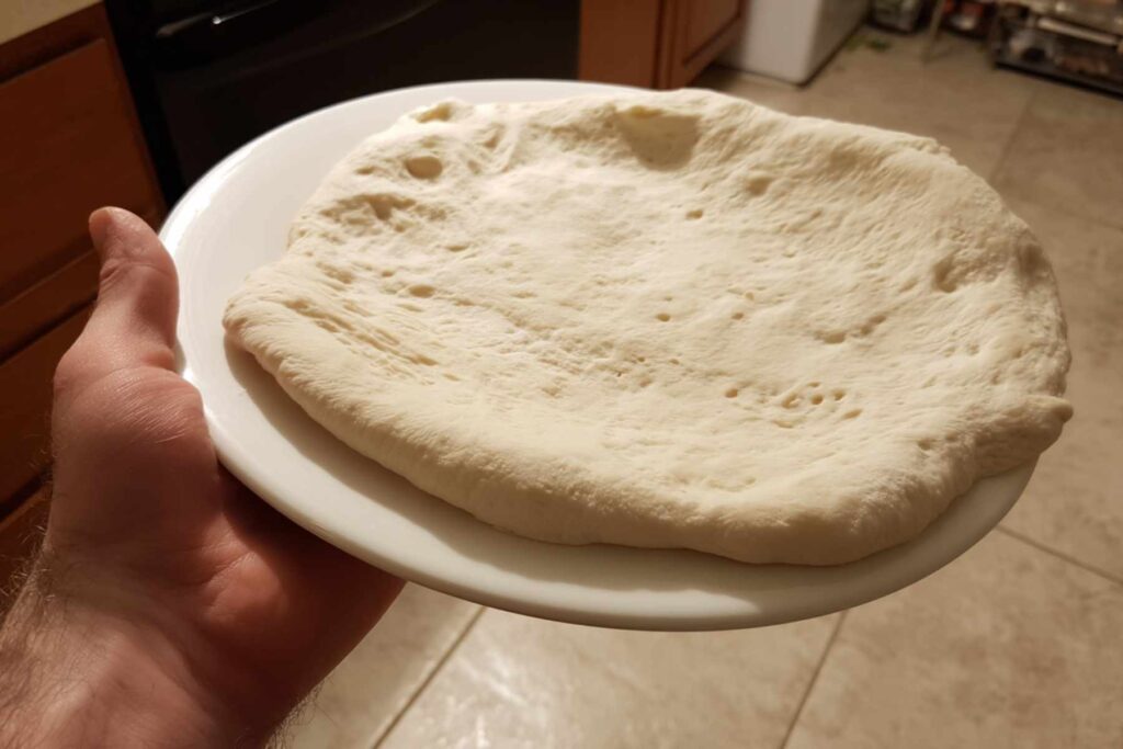 Hands kneading homemade pizza dough easy recipe on kitchen counter