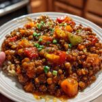 Bowl of vegetarian Mexican lentils with tomatoes and peppers on table