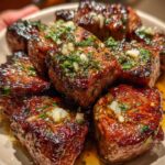 Garlic butter steak bites cooking in skillet with butter and garlic